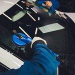 two guys replacing a car windshield